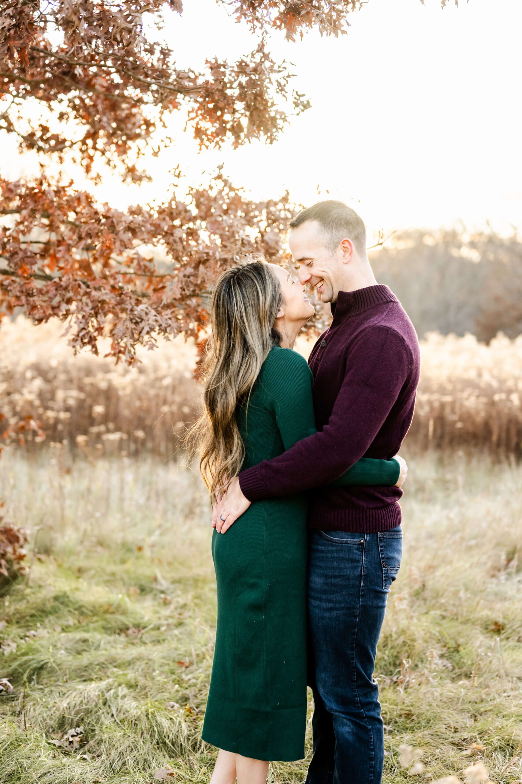 Couple touching noses and smiling in a close embrace with fall colors