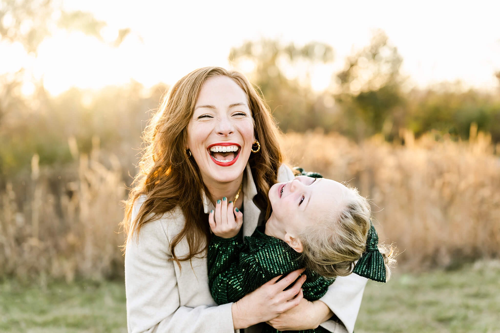Mother and daughter laughing in a golden field together Chicago Parent