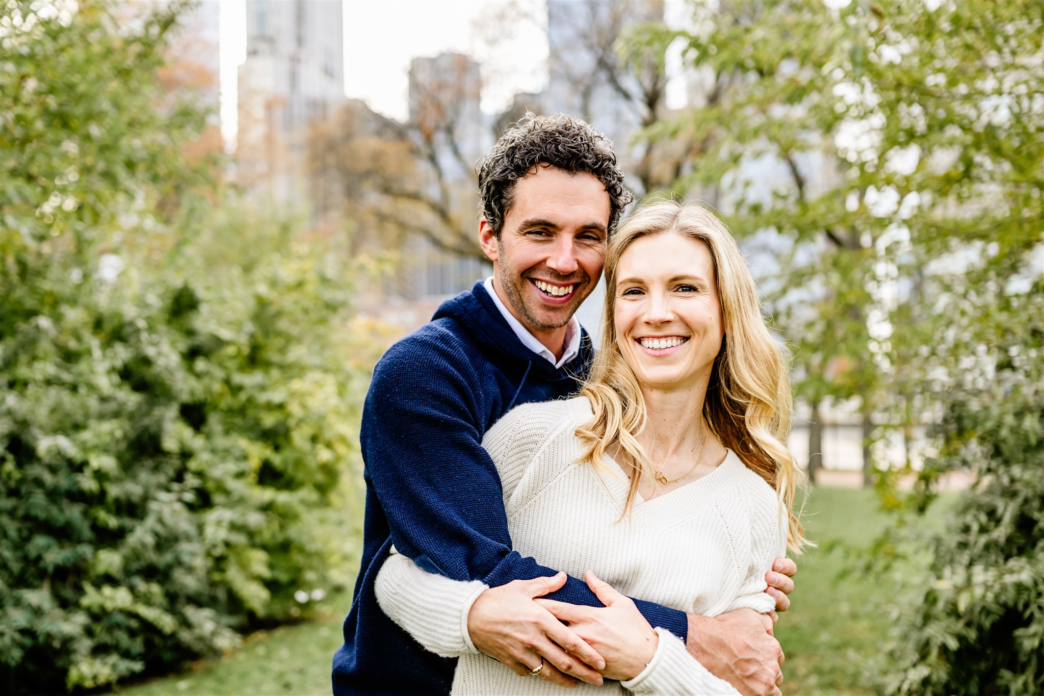 A happy couple hug in a downtown park before visiting Michelin Star Restaurants Chicago