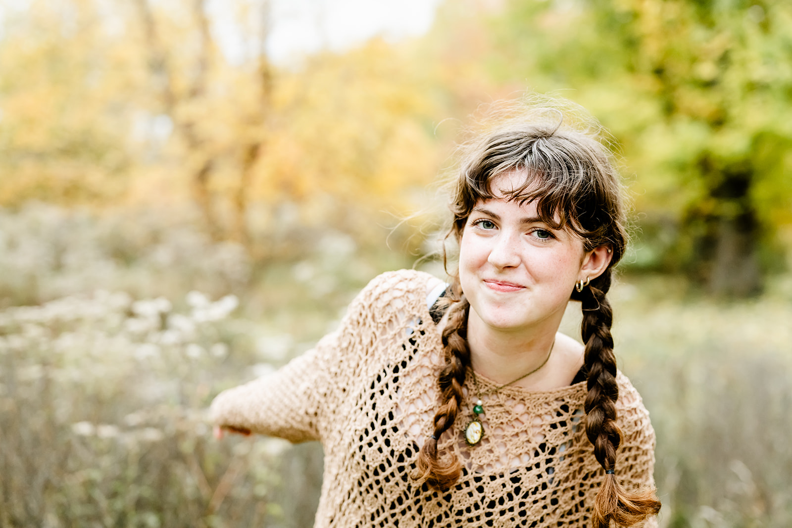 A teen girl in a brown blouse explores a park while smiling with braids after using tutors in Chicago