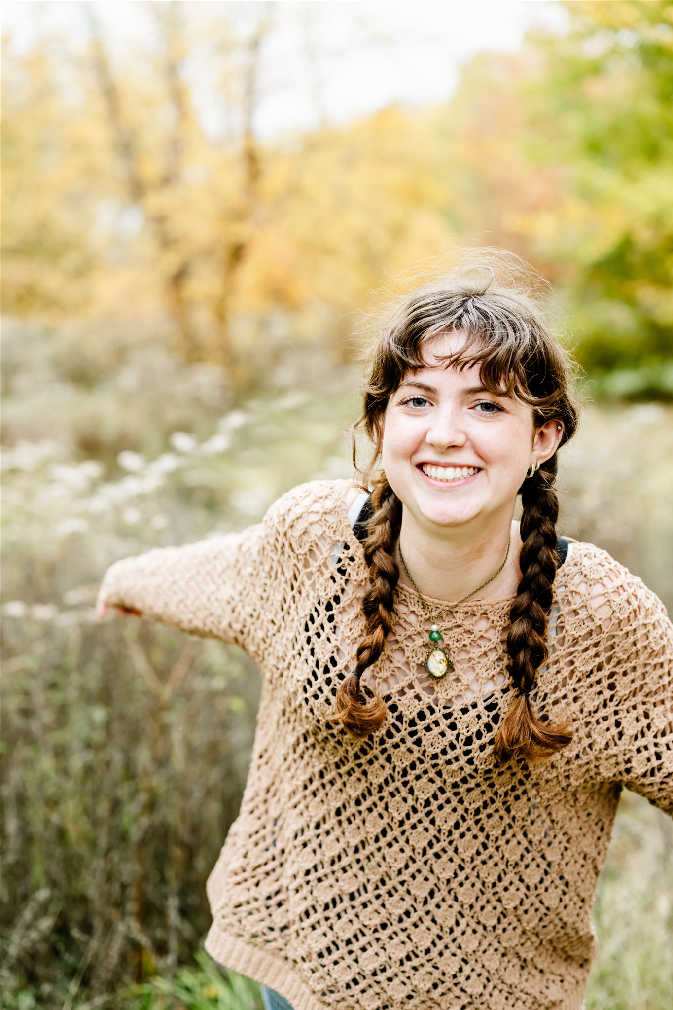 A happy teenager in a lace sweater dances in a park trail at sunset after visiting boutiques in Naperville
