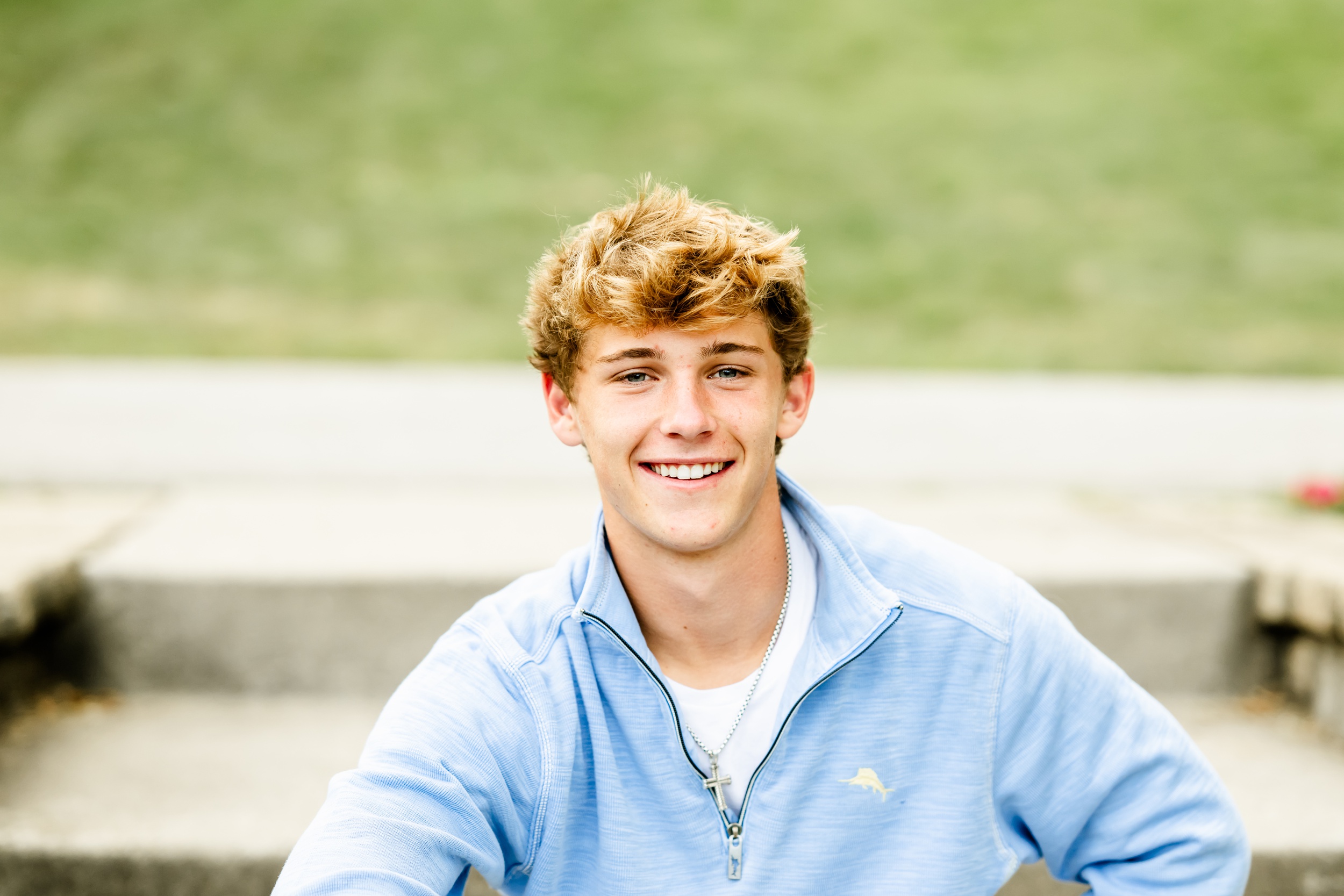 A high school senior smiles while sitting on park steps after finding great SAT prep in Naperville