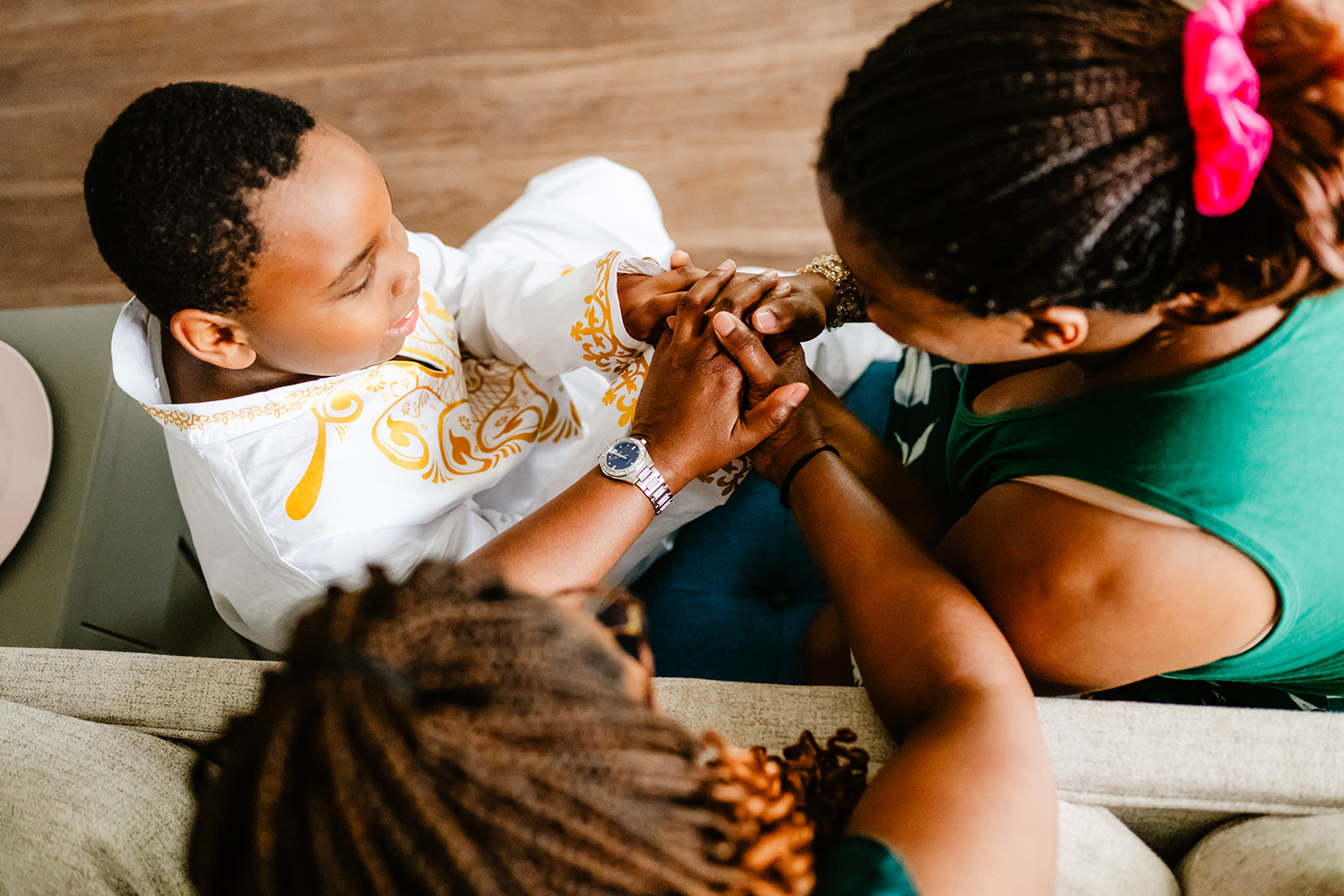 a family sits on a couch holding hands in green and white thanks to Imerman Angels
