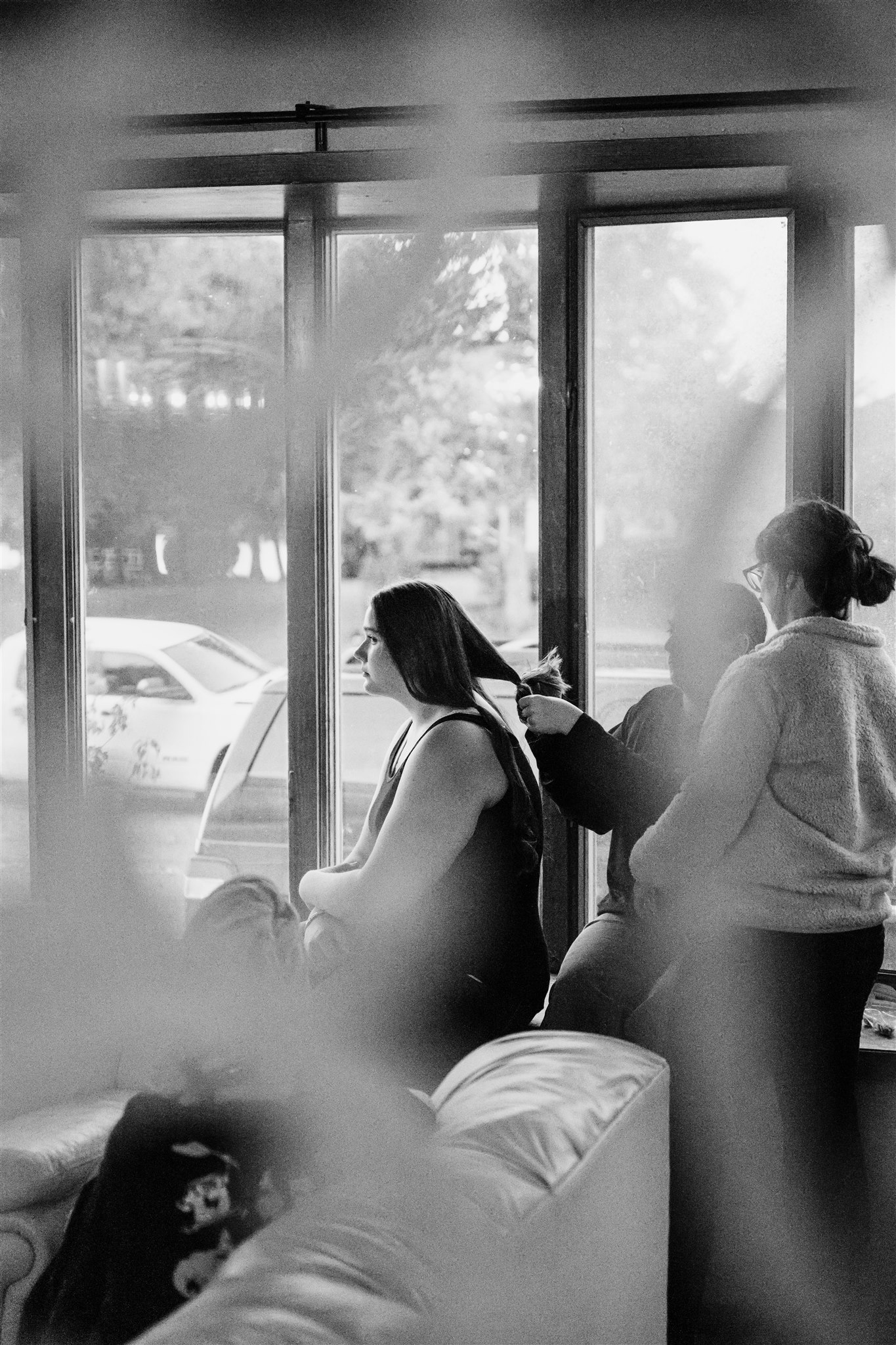 A woman sits in a window getting her hair cut after finding wigs for cancer patients in Chicago