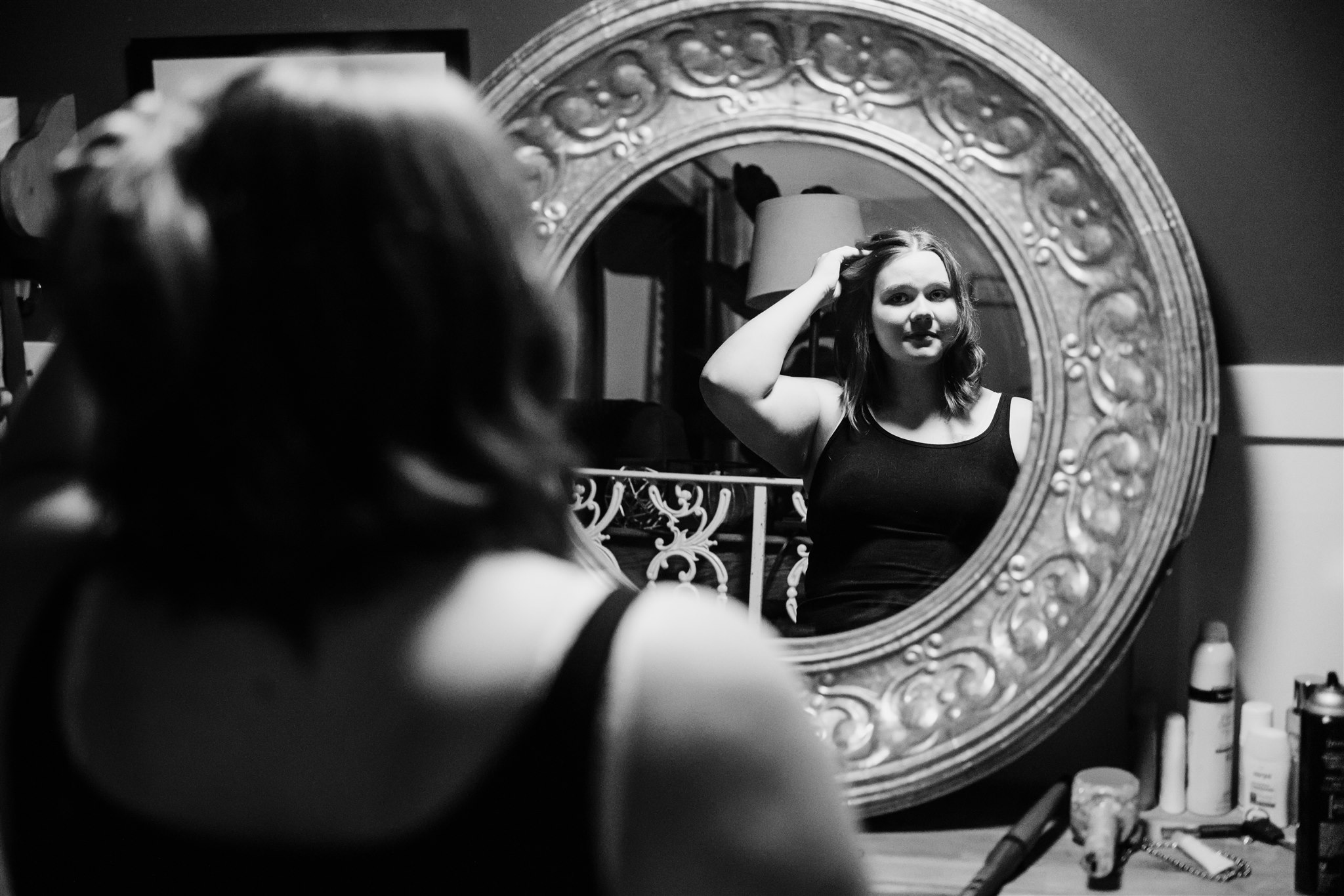 A woman admires one of her wigs for cancer patients in Chicago in a mirror while wearing a black top