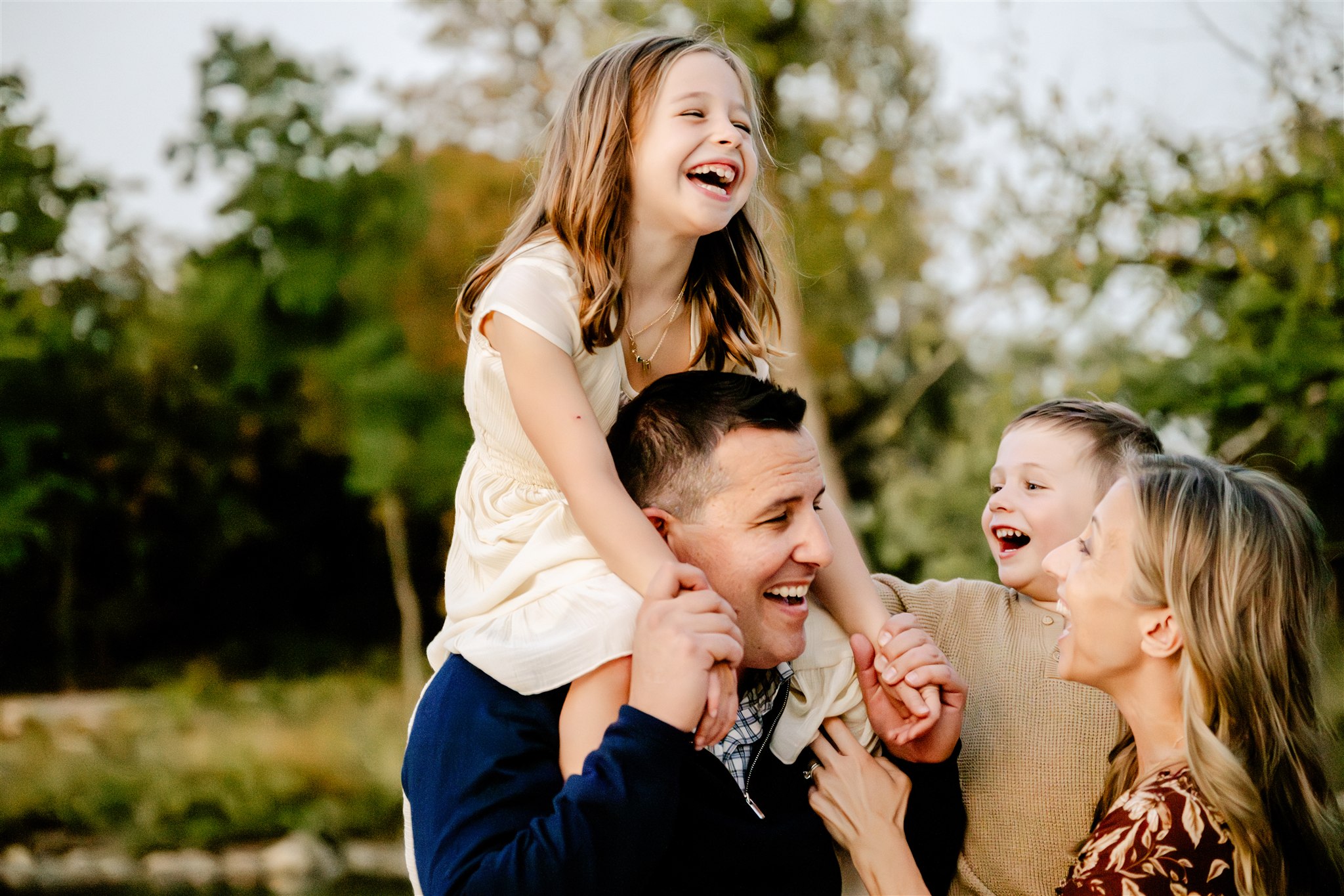 A happy family with two toddler laugh and play in a park after discovering private schools in Naperville