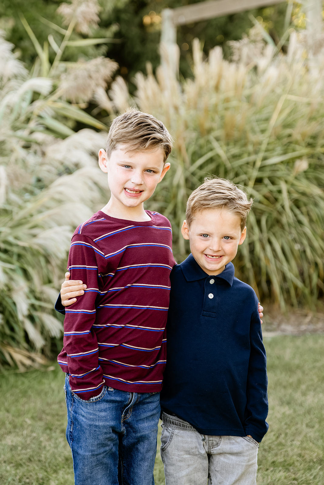 Happy young brothers stand in a lawn hugging and smiling while attending Montessori Schools in North Shore