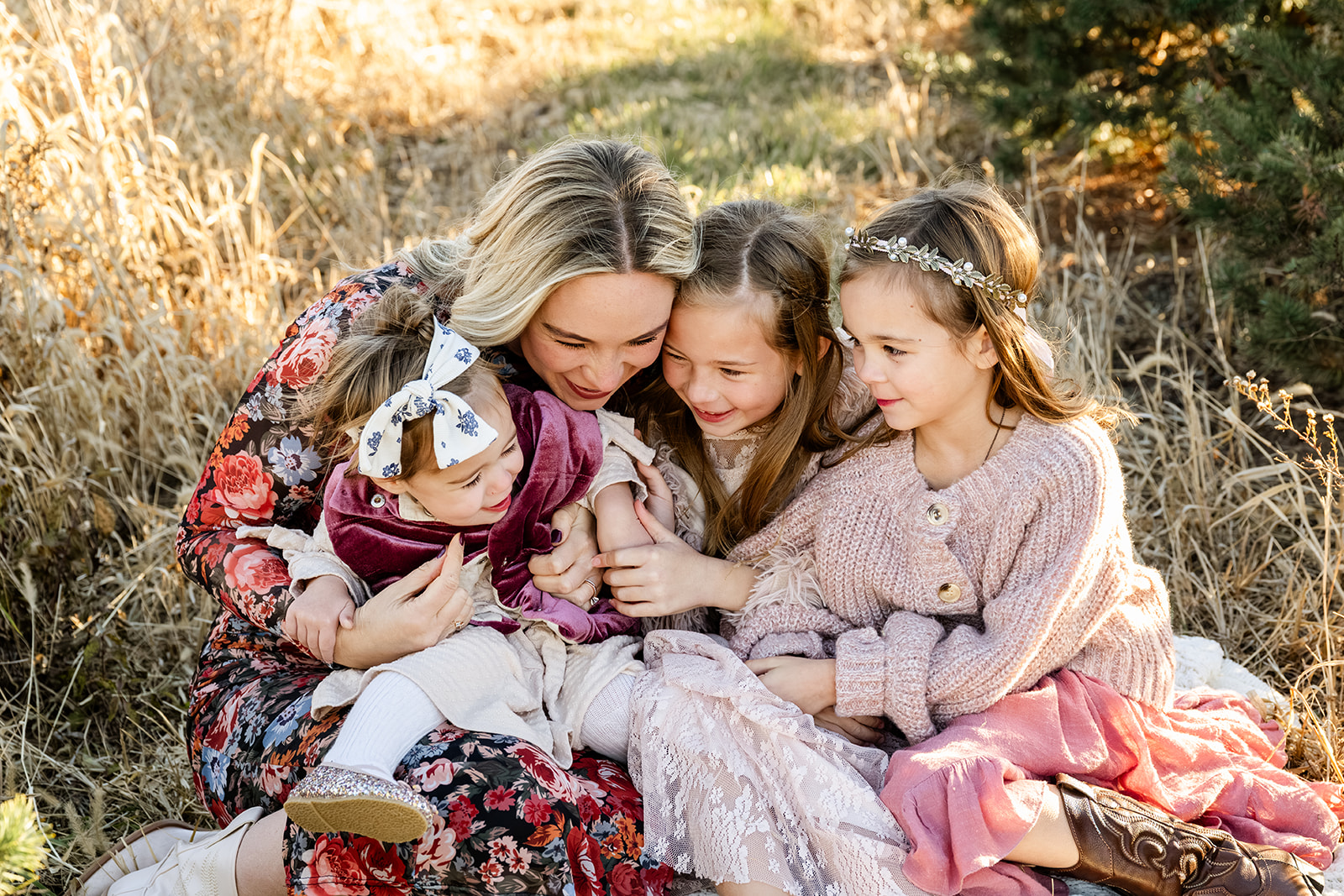 A happy mom tickles her youngest daughter in her lap with her two older girls after visiting Kohl Children's Museum