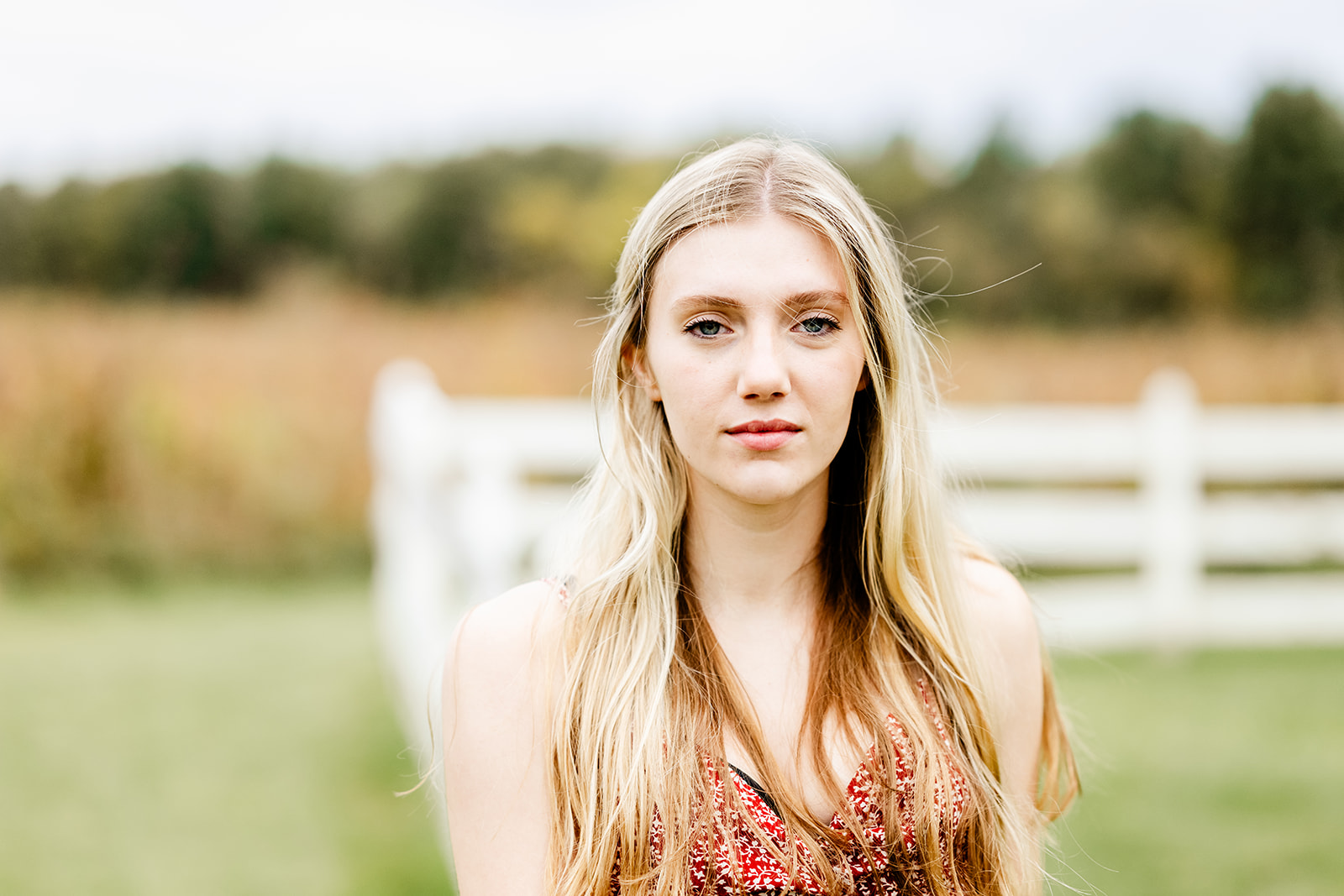 A closeup of a woman with blonde hair in a pasture