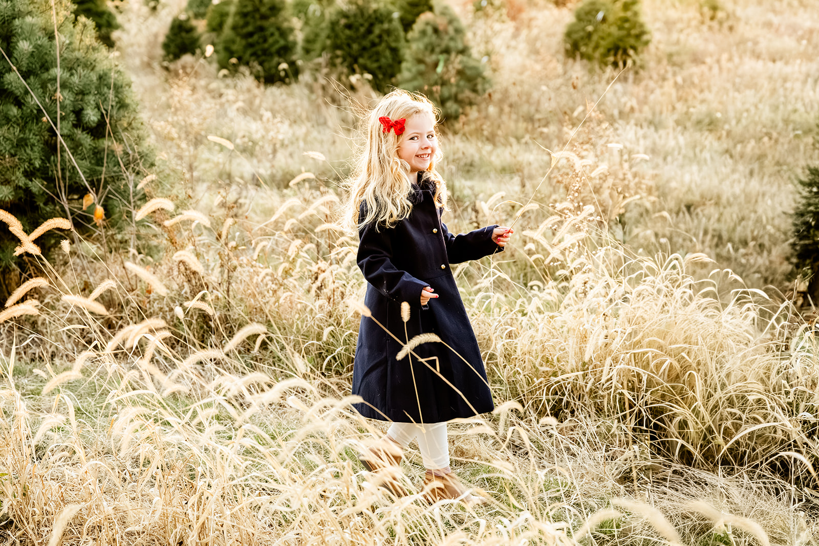 A young girl in a black coat walks in a christmas tree field before visiting sledding hills in Naperville